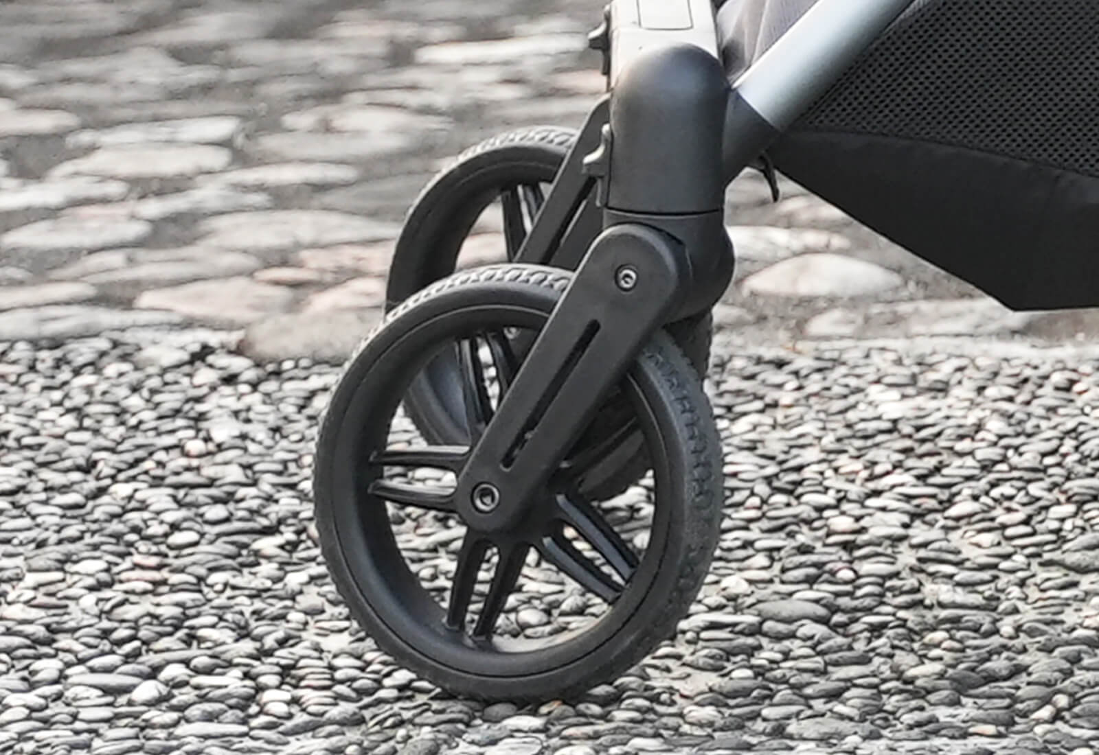 Close-up of a Ibiyaya Maxi pet stroller wheel on a pebbled surface
