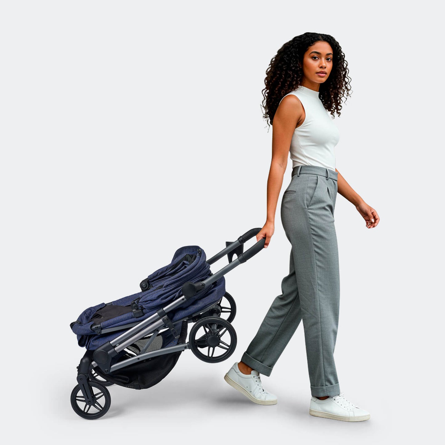 Woman pulling a folded blue Ibiyaya Maxi pet stroller on a white background