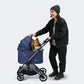 Person pushing a blue Ibiyaya Maxi pet stroller with a dog inside on a white background