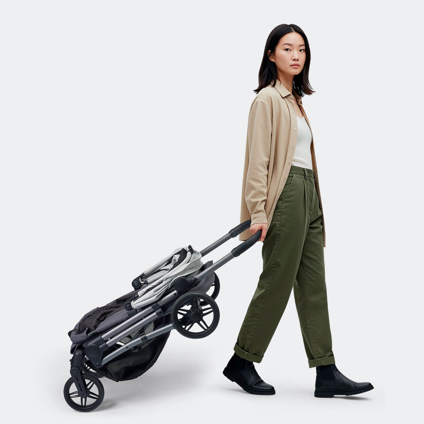Woman pulling a folded pet stroller made by Ibiyaya Maxi 