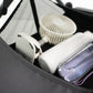 Inside of the storage space under a pet stroller showing a white fan, white bottle, and purple container inside