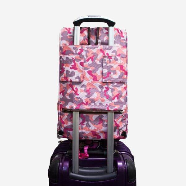 Back view of Petique airline approved dog carrier that has been securely slipped over a luggage's extendable handle.